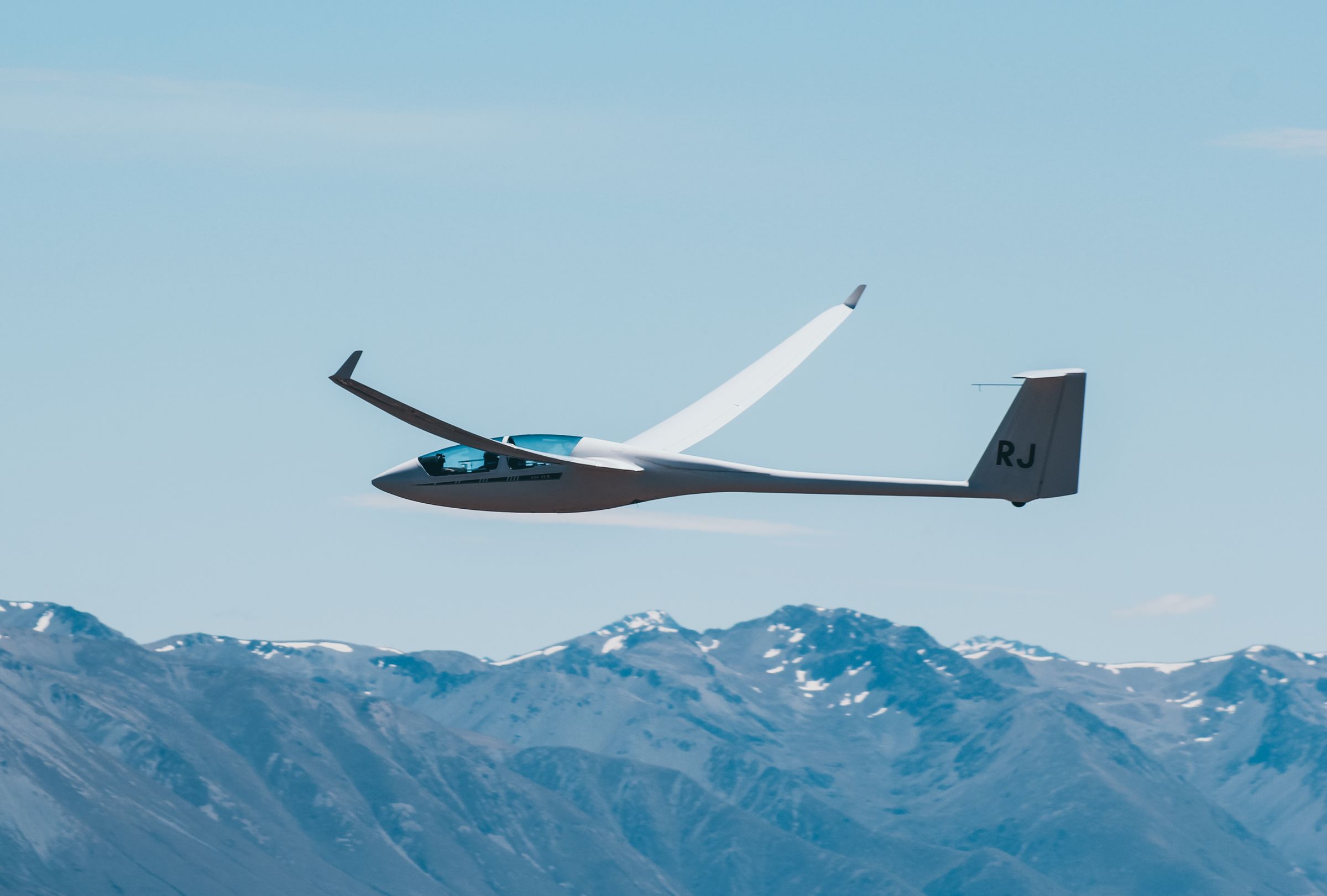 Segelflugzeug über schneebedeckten Bergen
